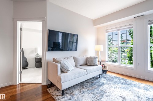 Hardwood flooring, white wall paint, white trim, recessed lighting, and a wall-mounted television - #230 45 Inglewood Dr, St. Albert, AB 