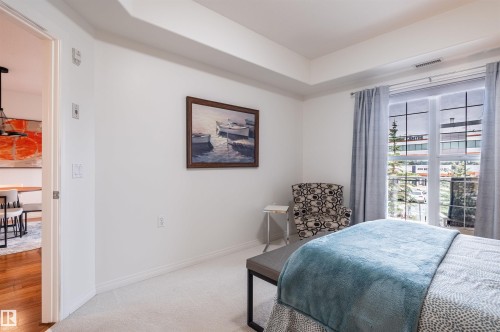 Neutral wall finishes, recessed ceiling detail, carpeted flooring, and a large window with vertical mullions - #230 45 Inglewood Dr, St. Albert, AB 
