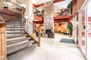 Grand two-story lobby featuring a curved staircase with wood banister and wrought iron spindles - #230 45 Inglewood Dr, St. Albert, AB 