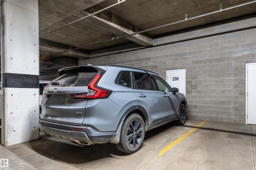 Dedicated parking space with concrete flooring, block wall construction, and exposed ceiling utilities - #230 45 Inglewood Dr, St. Albert, AB 