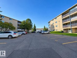 Multi-story building featuring private balconies, surface parking, and landscaped grounds - 