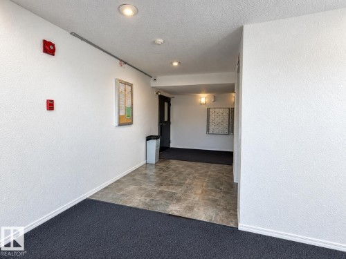 Entryway featuring recessed lighting, wall-mounted mailboxes, and a combination of carpet and hard-surface flooring - #108 2624 Mill Woods Rd E Nw, Edmonton, AB 