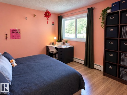 Wood-finish flooring, built-in shelving unit, double-pane window, and baseboard heating - #108 2624 Mill Woods Rd E Nw, Edmonton, AB 