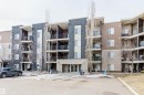 Exterior view of the property, featuring a multi-story building with balconies, a stone facade, and numerous windows - #204 11803 22 Av Sw, Edmonton, AB 