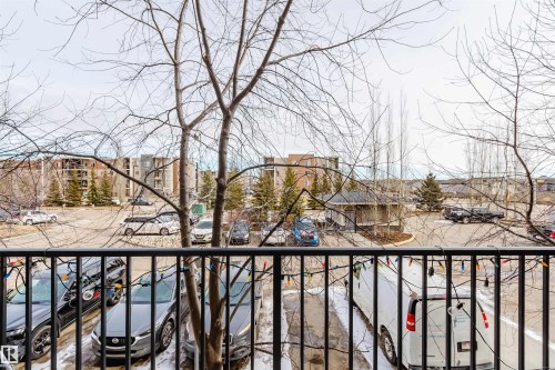 View overlooking the parking area with bare trees and various buildings in the distance - #204 11803 22 Av Sw, Edmonton, AB 