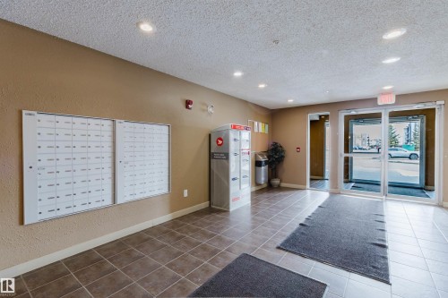 The property features a reception area with tiled flooring and recessed lighting - #204 11803 22 Av Sw, Edmonton, AB 