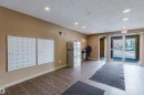 The property features a reception area with tiled flooring and recessed lighting - #204 11803 22 Av Sw, Edmonton, AB 