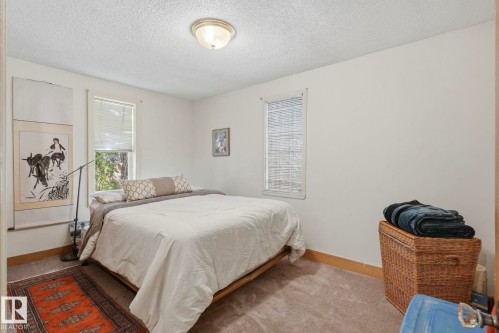 Neutral wall paint, textured ceiling, two windows with blinds, and a flush-mount ceiling light fixture - 9628 100A Street Nw, Edmonton, AB 