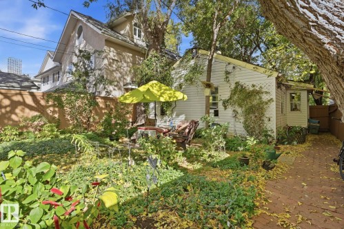Established garden space featuring mature foliage and a brick-paved pathway - 9628 100A Street Nw, Edmonton, AB 