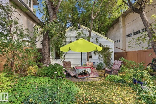 Expansive backyard with a manicured lawn, established trees, and a brick paver patio - 9628 100A Street Nw, Edmonton, AB 