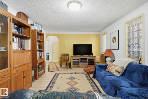 Light wood-finish flooring with a flush-mount ceiling light - 9628 100A Street Nw, Edmonton, AB 