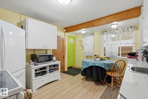 Wood-finish flooring, white cabinetry, integrated sink, and overhead lighting fixtures - 9628 100A Street Nw, Edmonton, AB 