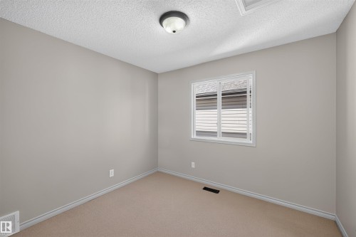 Neutral paint palette with carpeting, a single window, and overhead lighting - 6116 8 Avenue Sw, Edmonton, AB 