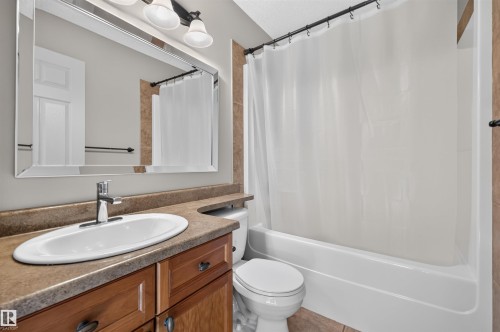 Vanity with a single basin, chrome faucet, and wood-finish cabinetry - 6116 8 Avenue Sw, Edmonton, AB 