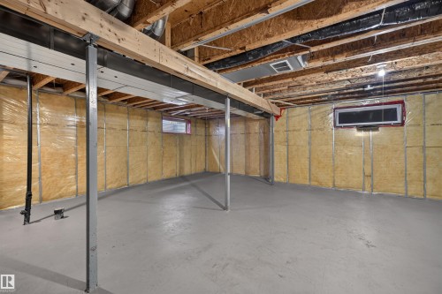 Unfinished basement with concrete flooring, exposed wood joists, structural support beams, and insulated walls - 6116 8 Avenue Sw, Edmonton, AB 