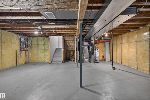 Expansive unfinished basement featuring concrete flooring, exposed ceiling joists, and insulated walls - 6116 8 Avenue Sw, Edmonton, AB 