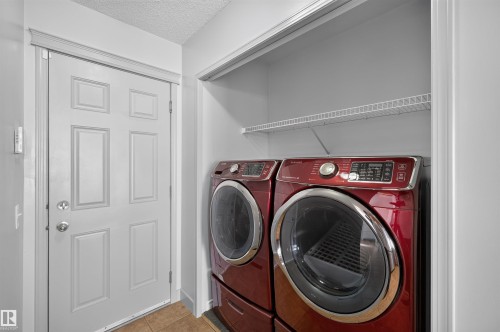 Laundry area featuring a side-by-side washer and dryer set, wire shelving, and light-toned wall paint - 6116 8 Avenue Sw, Edmonton, AB 