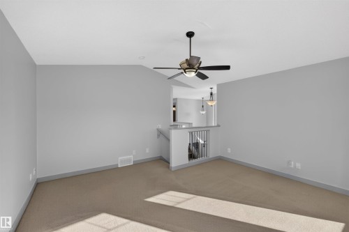 Carpeted flooring, contemporary ceiling fan, recessed lighting, and a half-wall partition with railing - 6116 8 Avenue Sw, Edmonton, AB 