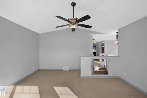 Vaulted ceiling with a ceiling fan, carpet flooring, interior railing, and recessed lighting - 6116 8 Avenue Sw, Edmonton, AB 