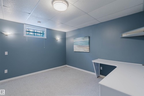 Recessed lighting, window with security bars, wall-mounted sconce lighting, built-in desk, and built-in shelving - 11526 9 Avenue Nw, Edmonton, AB 