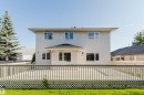 Expansive rear wood deck with lattice skirting, providing a substantial outdoor living area - 11526 9 Avenue Nw, Edmonton, AB 