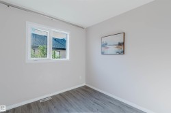 Wood-finish flooring with white trim, a double-pane window, and light neutral wall finishes - 