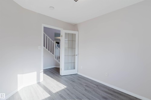Wood-finish flooring with light-toned walls - 11526 9 Avenue Nw, Edmonton, AB 
