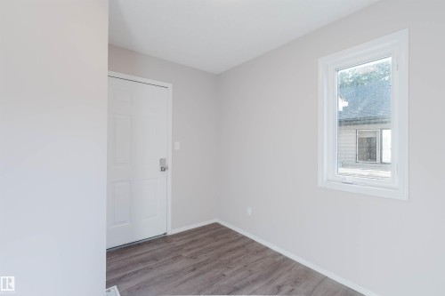 White interior door, single window, wood-finish flooring, and light-toned walls - 11526 9 Avenue Nw, Edmonton, AB 