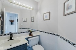 Vanity with integrated sink, black-finish faucet, and coordinating dark blue cabinetry - 