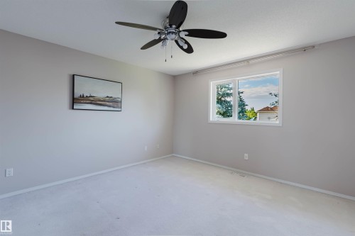 Carpeted flooring, a window with white trim, and a ceiling fan with integrated lighting - 11526 9 Avenue Nw, Edmonton, AB 