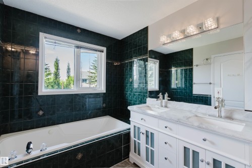Dual vanity with undermount sinks, stone countertop, and chrome fixtures - 11526 9 Avenue Nw, Edmonton, AB 