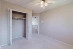 Light-toned walls, carpeted flooring, bi-fold closet, and a ceiling fan with integrated lighting - 