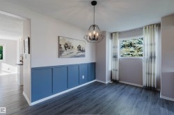 Wood-finish flooring, a contemporary geometric chandelier, and an accent wall with board and batten detailing - 