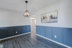 Wood-finish flooring, accent wall paneling, and an open-cage geometric pendant light fixture - 