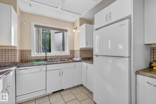 White appliances, dual basin sink, white cabinetry, tiled flooring, and tiled backsplash - 11 Howson Crescent Nw, Edmonton, AB 