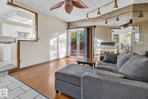 Wood-finish flooring, sliding glass door, built-in ceiling fan, track lighting, and a mirrored wall accent - 11 Howson Crescent Nw, Edmonton, AB 