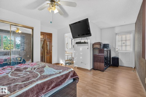 Wood-finish flooring, ceiling fan, mirrored closet doors, and private exterior door - 11 Howson Crescent Nw, Edmonton, AB 