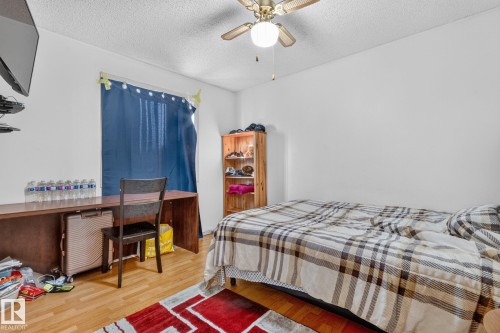Wood-finish flooring, ceiling fan with integrated lighting, window with curtain rod, white walls, and built-in shelving - 11 Howson Crescent Nw, Edmonton, AB 