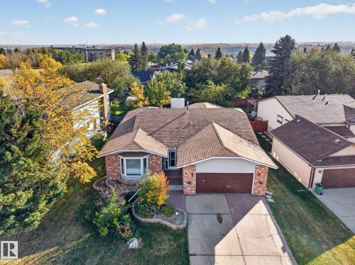 Brick-front exterior with a bay window, concrete driveway, attached garage, and a shingle roof - 11 Howson Crescent Nw, Edmonton, AB 