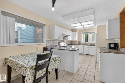 Kitchen featuring white cabinetry, stone-finish countertops, tiled backsplash, and recessed lighting - 11 Howson Crescent Nw, Edmonton, AB 