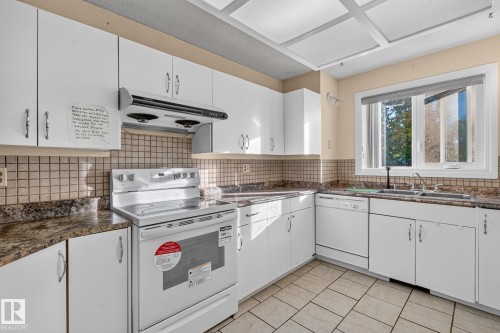 White cabinetry, tile flooring, stone-finish countertops, stainless steel sink, and a built-in range - 11 Howson Crescent Nw, Edmonton, AB 