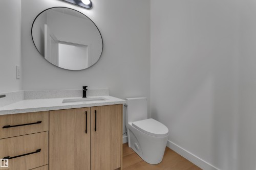 Light wood-finish vanity with matte black hardware, white countertop, and integrated sink - 58 Silverstone Drive, Stony Plain, AB 