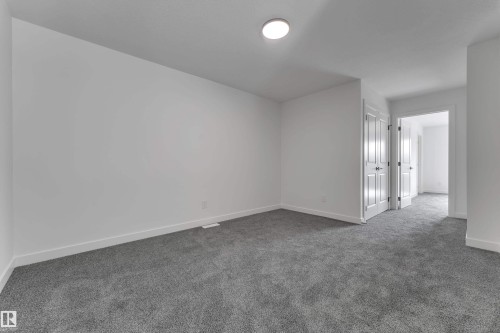 Neutral white wall paint, flush mount ceiling lighting, and gray carpeting - 58 Silverstone Drive, Stony Plain, AB 