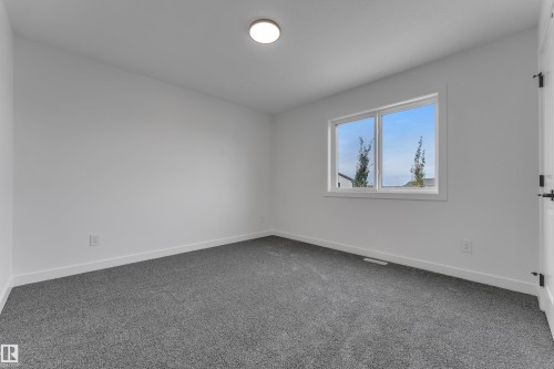 Bright room featuring a single window, white walls, and gray carpet flooring - 58 Silverstone Drive, Stony Plain, AB 