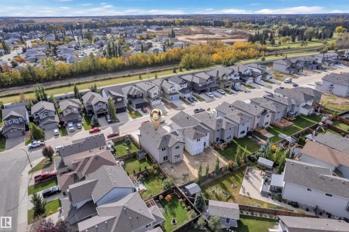 Aerial perspective of a residential street with uniform modern homes featuring dark roofs and light-colored siding - 58 Silverstone Drive, Stony Plain, AB 