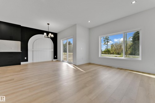 Light wood-finish flooring throughout, recessed lighting, and a large picture window - 261 Linden Loop, Leduc, AB 