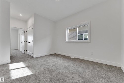 Neutral wall color, recessed lighting, double bi-fold doors, white trim, grey carpeting - 261 Linden Loop, Leduc, AB 