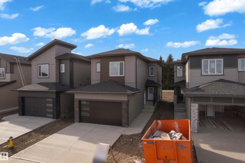Contemporary exterior siding with stone accents, attached single-car garage, concrete driveway, and front entry - 261 Linden Loop, Leduc, AB 