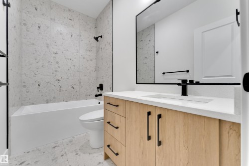 Floating vanity with wood-finish cabinetry, quartz countertop, and integrated sink - 261 Linden Loop, Leduc, AB 