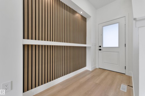 Entryway featuring a wood-slat accent wall, recessed lighting, and a built-in shelf - 261 Linden Loop, Leduc, AB 